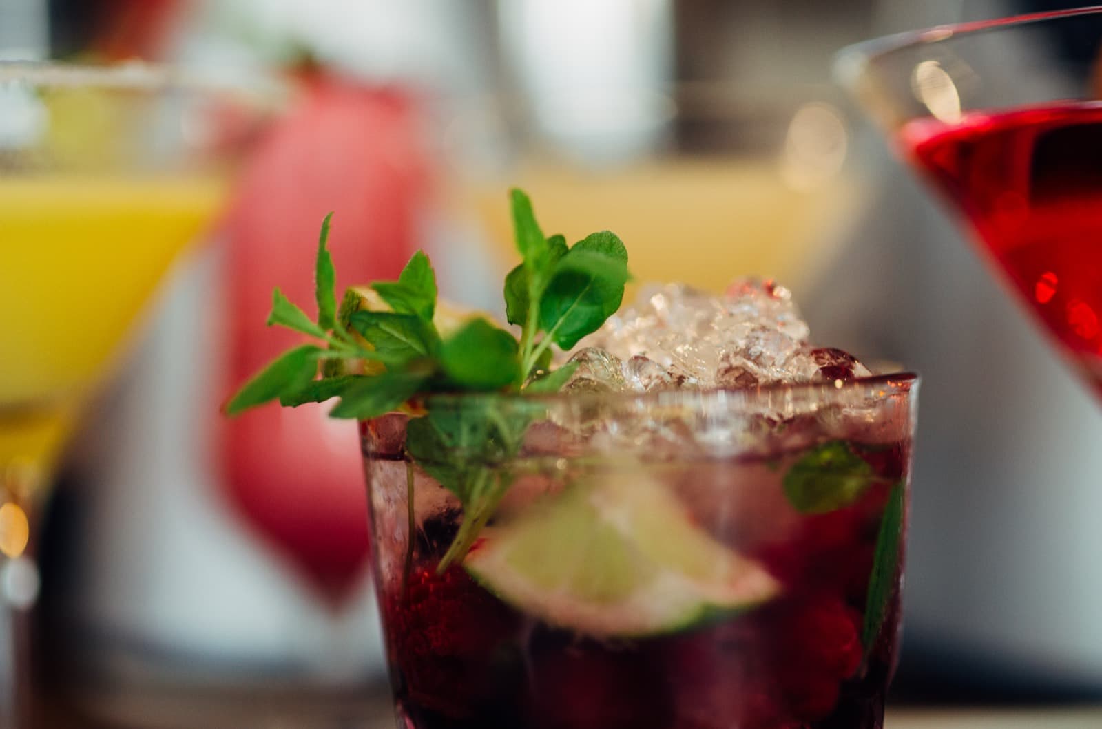 Colourful drinks with fresh ingredients laid out on a bar counter