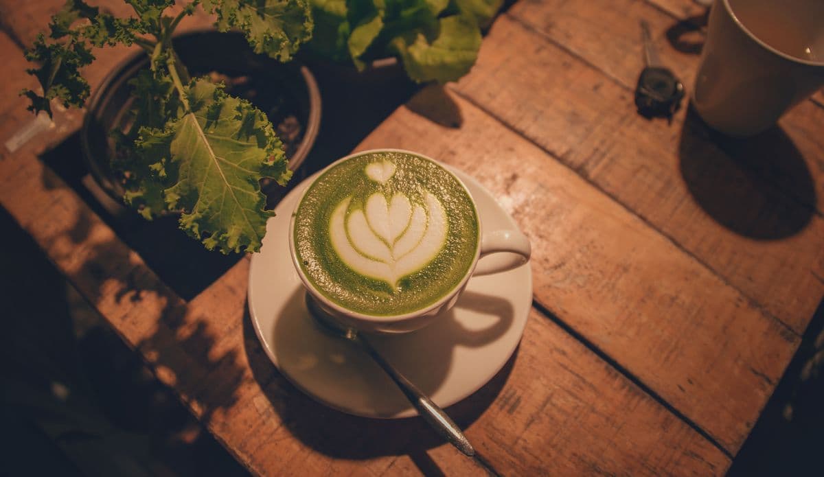 Matcha green tea powder and brewing tools on a table