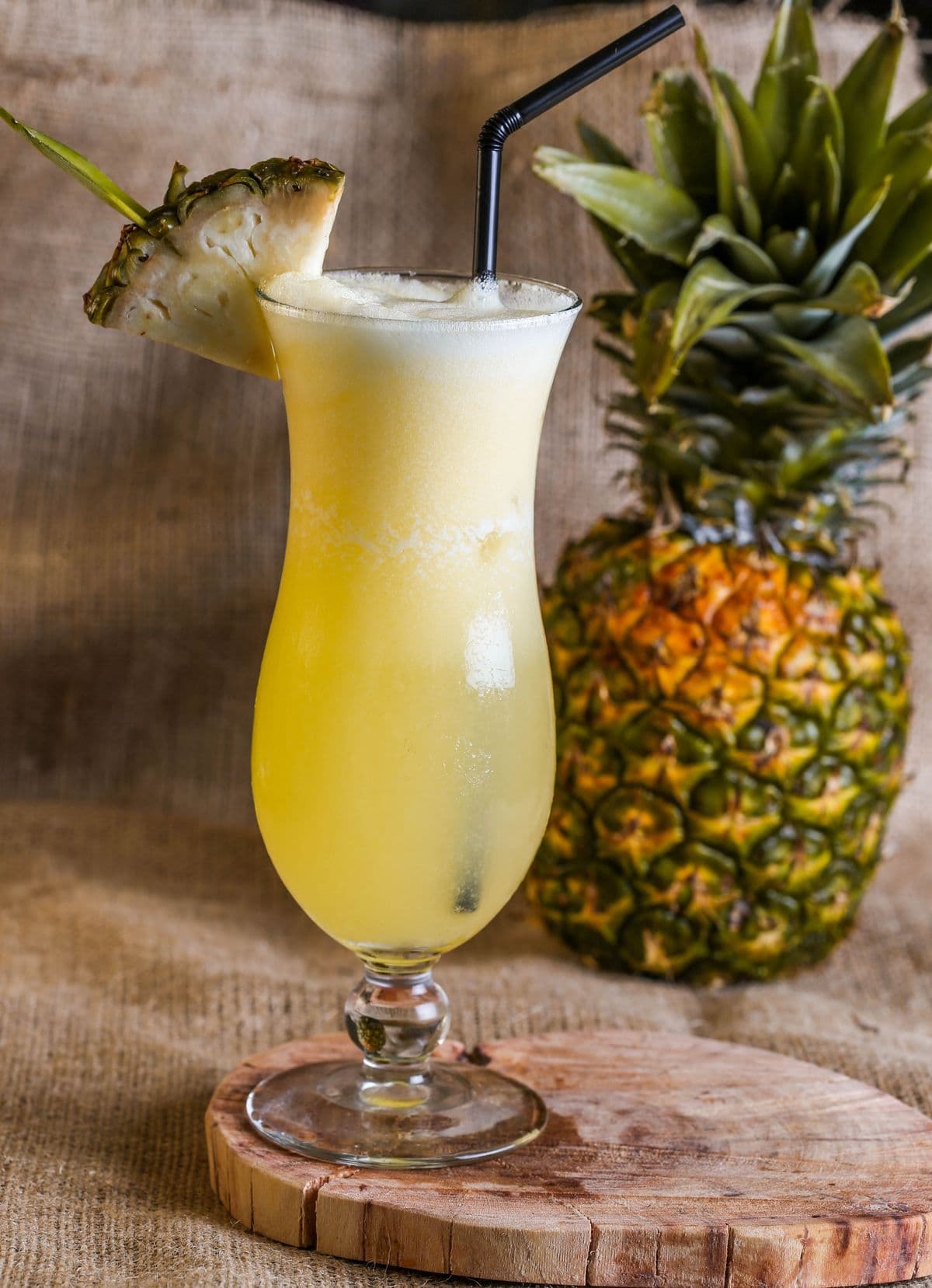 A refreshing glass of pineapple juice garnished with fresh pineapple slices