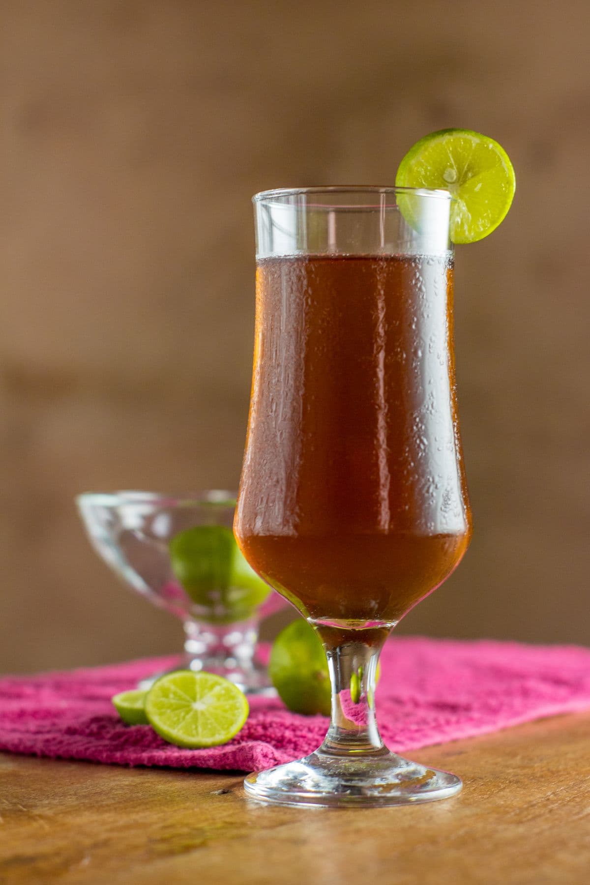 Close up of a cold salted plum calamansi tea with ice and calamansi slices